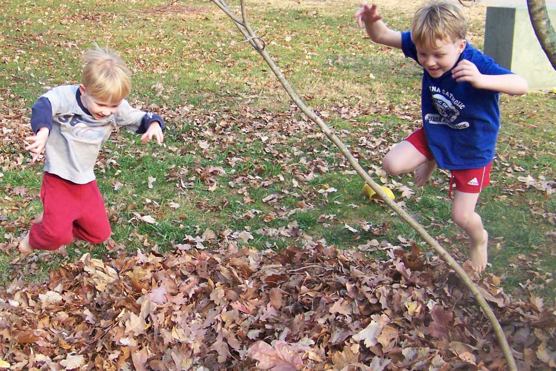 Therapy for Anxiety, ADHD, and Burnout for Moms. Two boys jumping in leaves with excitement. 