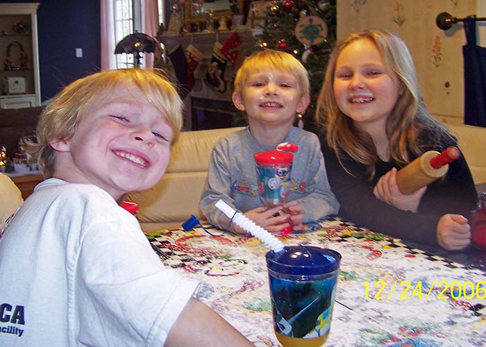 balance self-care holidays moms. Three smiling kids making christmas cookies