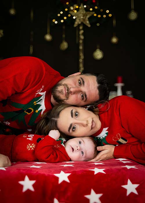 balance self care holidays.  family and baby with heads together on table at Christmas<br />
