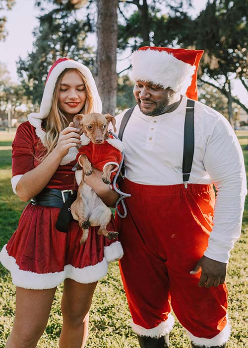 balance self-care holiday. Couple dressed as mr and mrs Claus with dog in xmas costume too