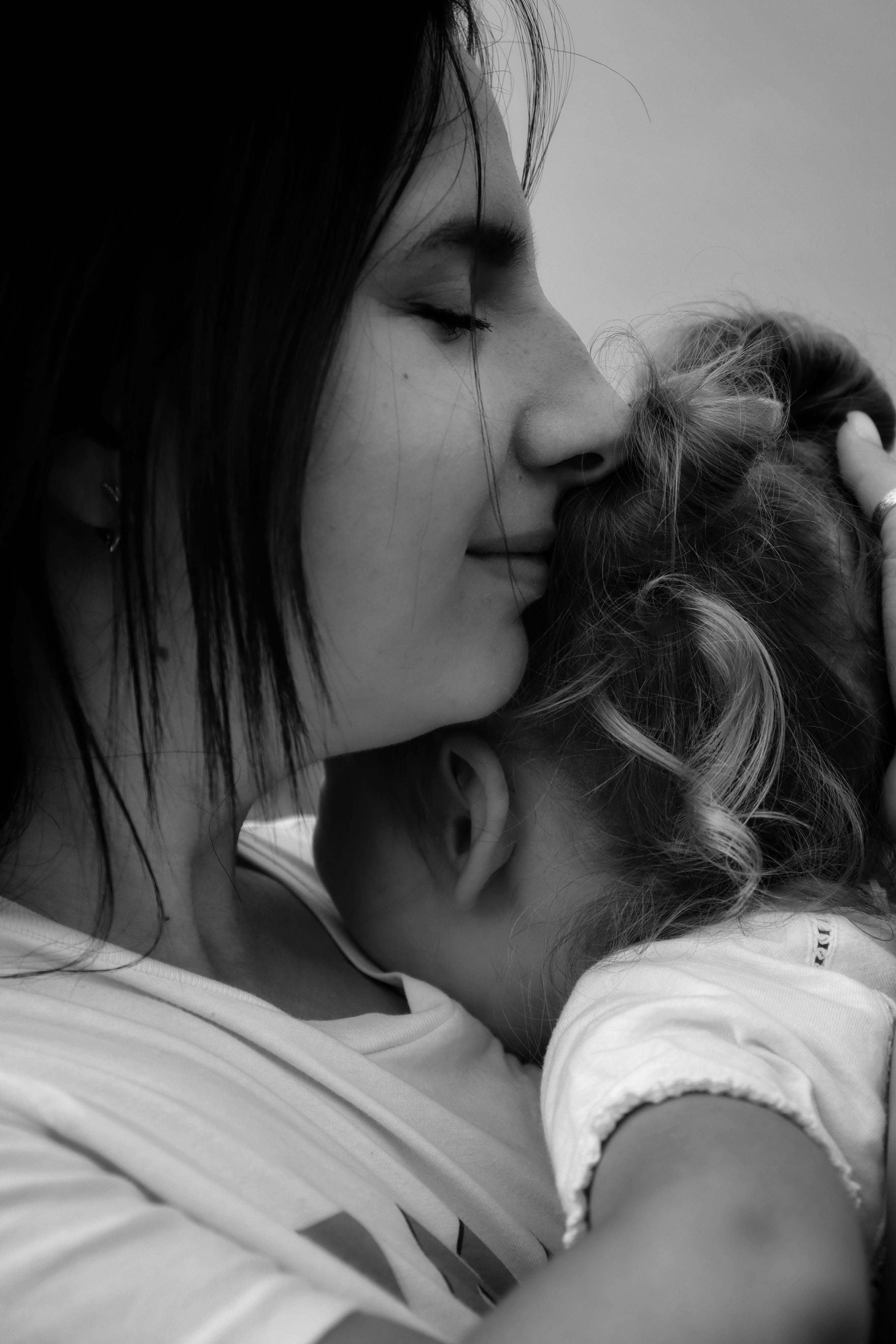 momhuggingtoddlergrief grief therapy. Mom hugging toddler in bandw